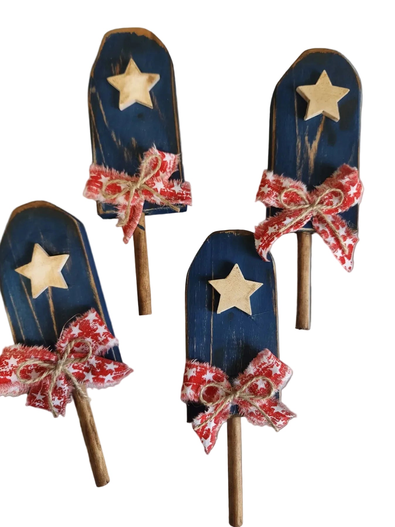 Decorative wooden shovels with stars and red bows on a light background