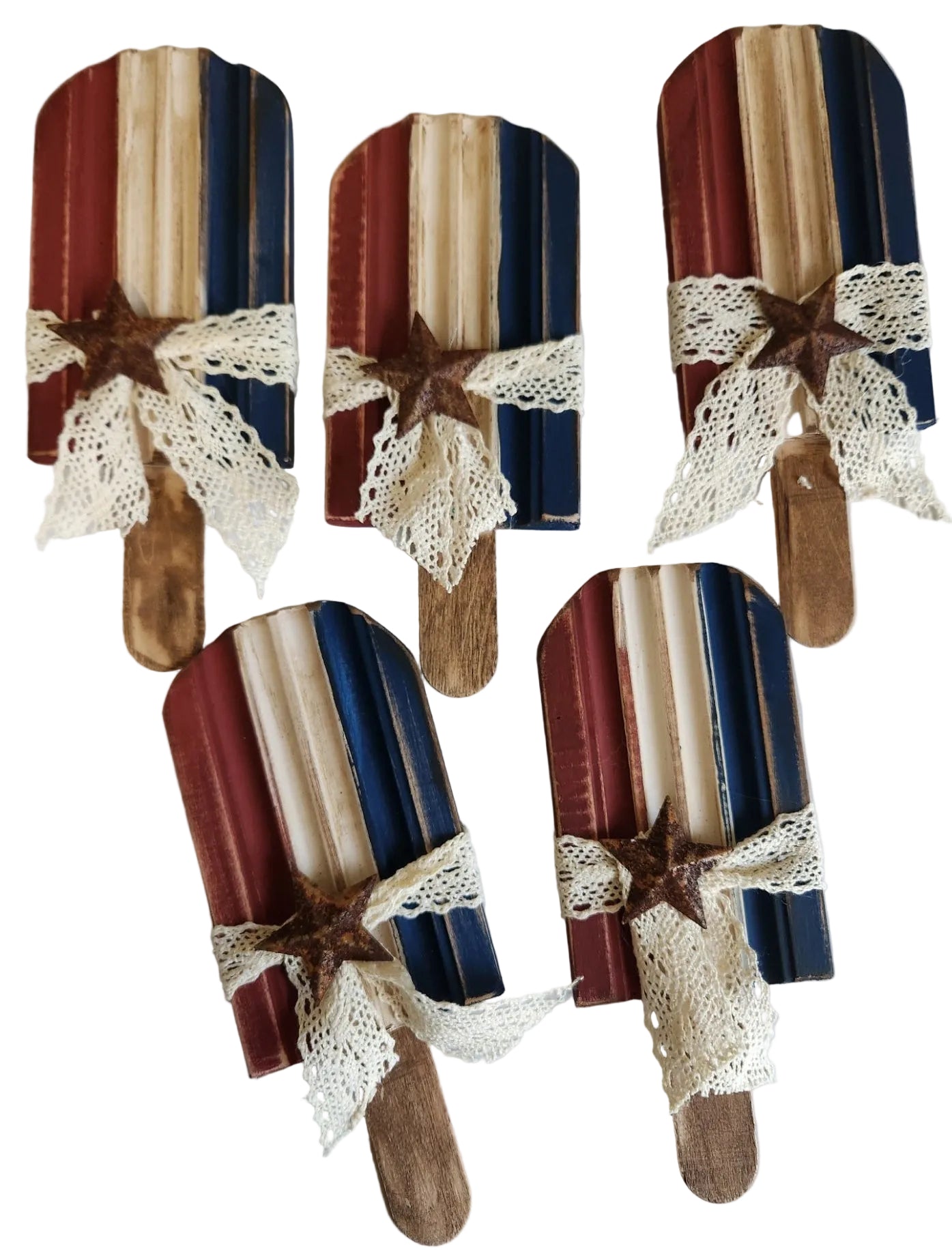 Set of decorative wooden spoons with lace and star embellishments on a white surface