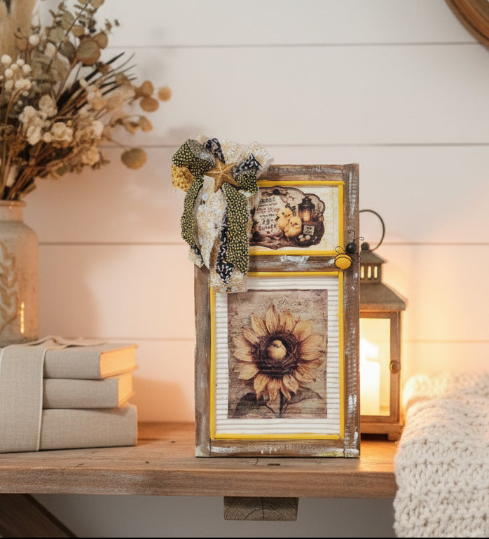 Decorative wall piece with framed images and fabric accents on a white background