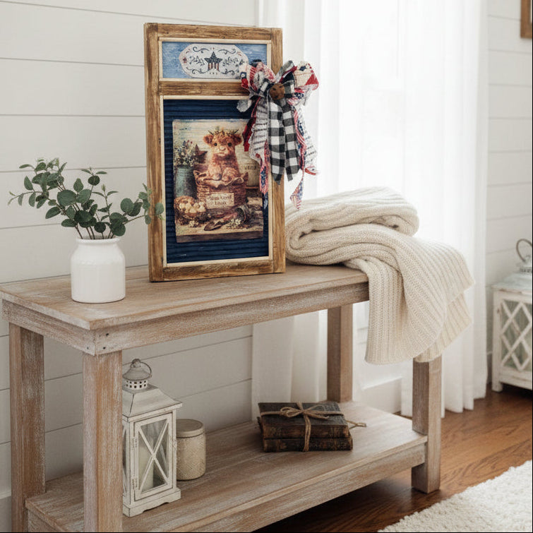 Decorative wall art with a wooden frame, ribbons, and a painting of a castle.